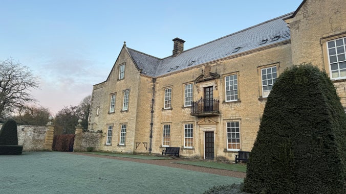 Sidewards view across a frosty garden of a large manor house